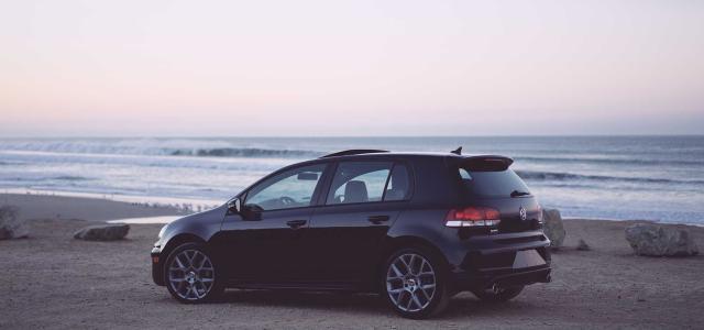 Volkswagen golf on the beach with ocean in background.
